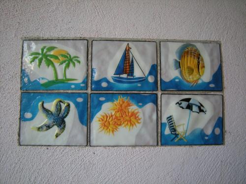 a group of four tiles with different pictures on a wall at Mare & Mirice - Case Appartamenti Vacanza in Aglientu