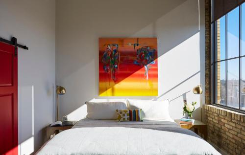 a bedroom with a bed and a painting on the wall at Kinn Guesthouse Bay View in Milwaukee