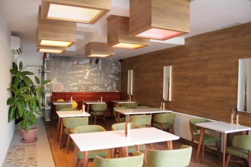 a restaurant with tables and chairs and a chalkboard at Saray Hotel in Prizren