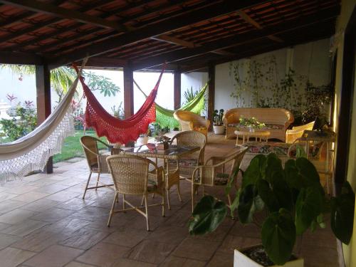 eine Terrasse mit einem Tisch, Stühlen und einem Klavier in der Unterkunft Pousada da Mércia - Itapuã (BA) in Salvador