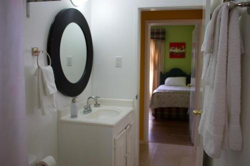 uma casa de banho com um lavatório, um espelho e uma cama em Penthouse On The Ridge em Ocho Rios