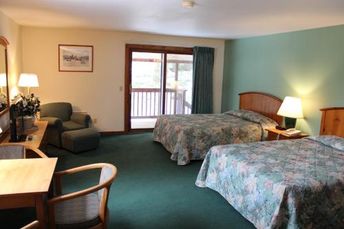 a hotel room with two beds and a balcony at Nootka Lodge in Woodsville