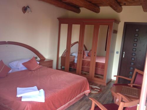 a bedroom with a red bed and a mirror at Pensiunea la Nise in Sîmbăta de Sus