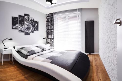 ヴロツワフにあるPrestige Apartaments 79のベッドルーム(白黒のベッド1台、窓付)