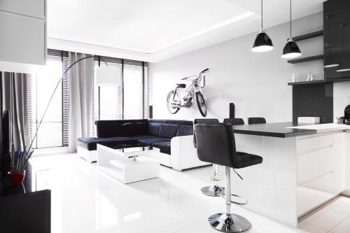 a kitchen and living room with a blue couch at Prestige Apartaments 79 in Wrocław