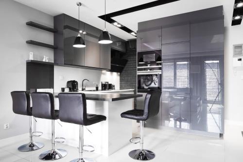 a kitchen with black chairs and a kitchen island at Prestige Apartaments 79 in Wrocław