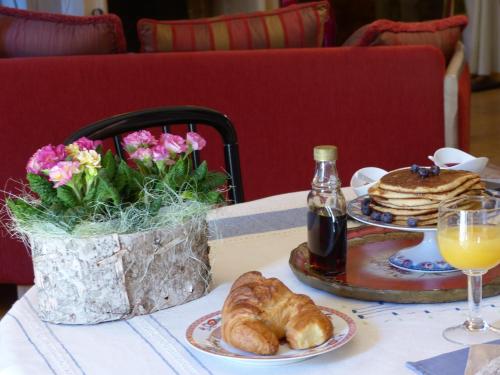 una mesa con un plato de cruasanes y una botella de refresco en La Mirandole, en Foix