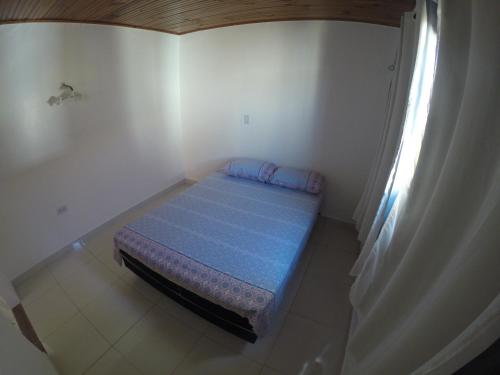 a small bedroom with a blue bed in a room at Hostel Aventura in Alto Paraíso de Goiás