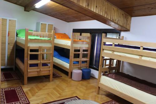 a room with four bunk beds in a house at Hostel Trajan in Donji Milanovac