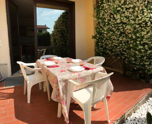 - une table avec des chaises blanches et un chiffon de table sur la terrasse dans l'établissement Cinzia's Home, à Raffa