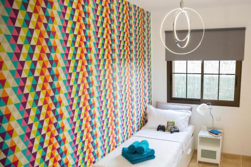 a bedroom with a colorful wall with a bed at Beautiful Villa Grace, Caleta de Fuste in Caleta De Fuste