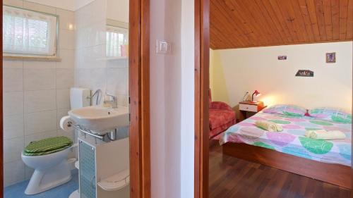 a bathroom with a sink and a bed in a room at Apartments Bernic in Medulin