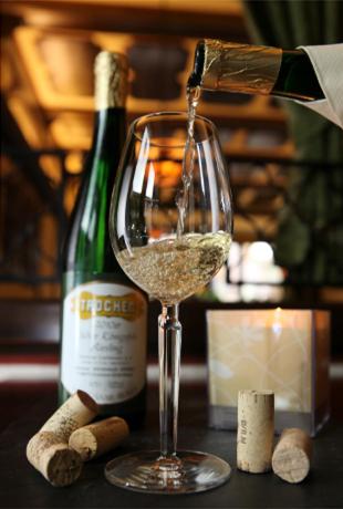 a glass of white wine is being poured at Hotel-Restaurant Weinhaus Grebel in Koblenz