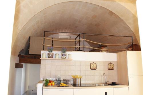 una cucina con lavandino e muro di mattoni di Casa vacanza L'antico fontanino a Montescaglioso
