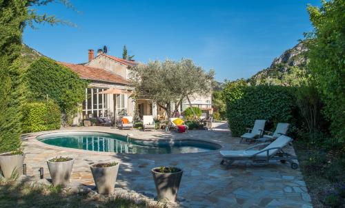une maison avec une piscine dans une cour dans l'établissement Hameau d'hôtes La Roseraie-Drôme, à Condorcet