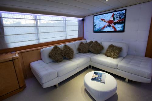 sala de estar con 2 sofás blancos y TV en Riti Yacht, en Kalkara