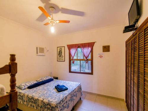 1 dormitorio con 1 cama y ventilador de techo en Ilha House Suítes en Ilhabela