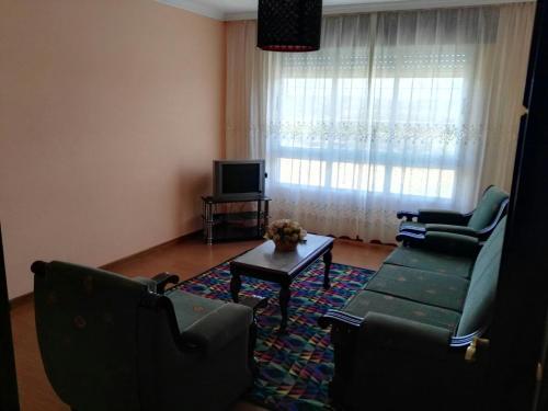 sala de estar con sofá, 2 sillas y mesa en Arzúa Home, en Arzúa