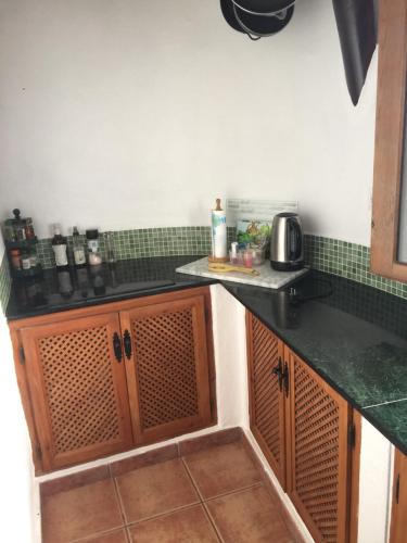 a kitchen with a black counter top and green tiles at Cueva Chelaja in Galera