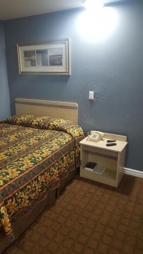 a hotel room with a bed and a phone on a table at Travel Inn in Sharonville