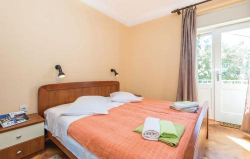 a bedroom with a bed with two towels on it at APARTMANI SANDRA PRPIĆ in Rab