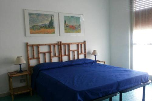 カスティリオーネ・デッラ・ペスカーイアにあるAppartamento l'Approdoのベッドルーム1室(青いベッド1台、ランプ2つ付)