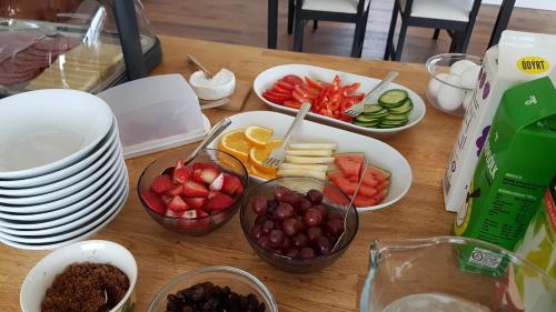 a table with bowls of fruit and plates on it at Hafdals Hotel in Akureyri