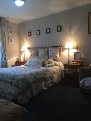 Un dormitorio con una cama grande con dos lámparas. en Lihuen Villarrica, en Villarrica