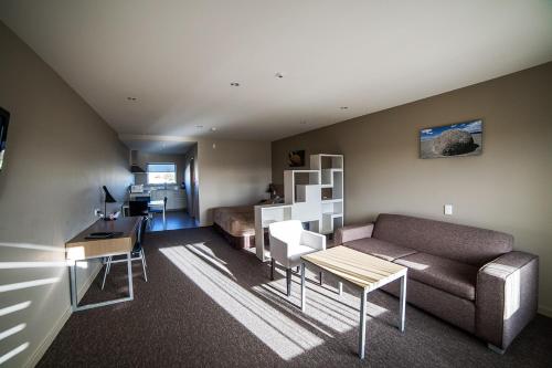 ein Wohnzimmer mit einem Sofa und einem Tisch in der Unterkunft Northstar Motel in Oamaru