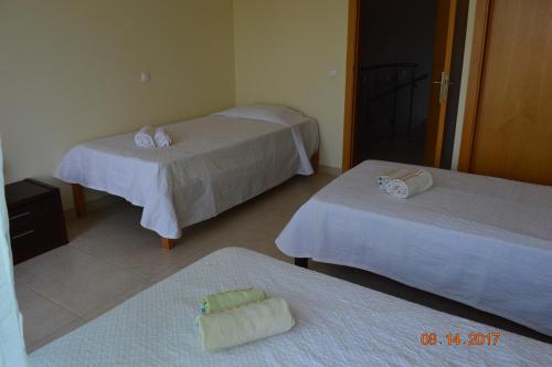 a hotel room with two beds and two towels at Vila Branca in Mosqueira