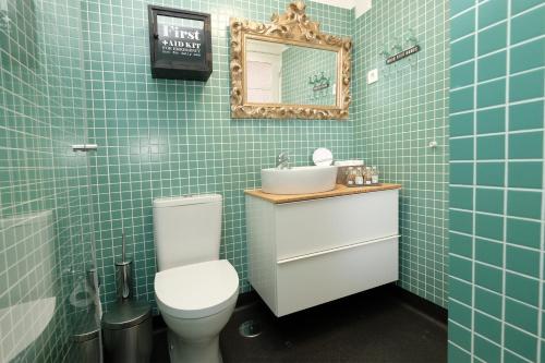 a bathroom with a toilet and a sink and a mirror at Porto Duke's House in Porto