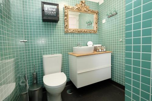Un baño con inodoro, lavabo y espejo. en Porto Duke's House, en Oporto