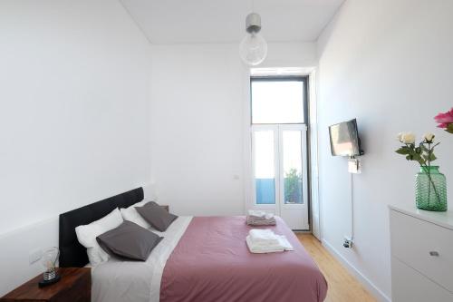 um quarto branco com uma cama grande e uma janela em Porto Duke's House no Porto
