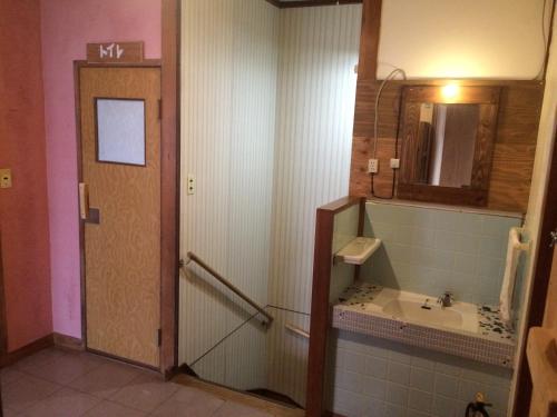 uma casa de banho com um lavatório e um espelho em Fujiya em Matsuyama
