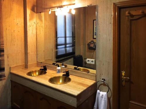 łazienka z dwiema umywalkami i dużym lustrem w obiekcie BOOKINGHAM ★Apartaments & Suites w Madrycie