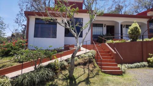 a house with stairs in front of it at Hotel Cielo Azul Resort in Tilarán