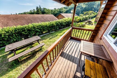a wooden deck with a bench and a window at Jeju I've Hotel & Resort in Seogwipo