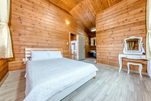a bedroom with a bed and a wooden wall at Jeju I've Hotel & Resort in Seogwipo