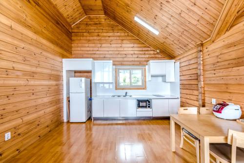 a kitchen with white appliances and a wooden ceiling at Jeju I've Hotel & Resort in Seogwipo