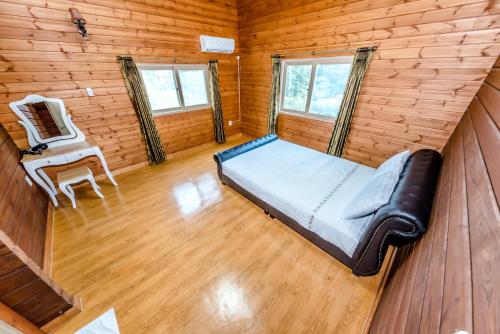 a bedroom with a bed and a chair in a room at Jeju I've Hotel & Resort in Seogwipo
