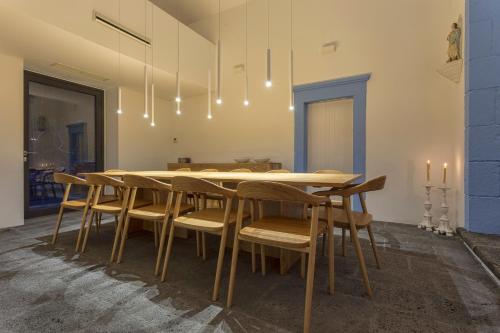 a dining room with a wooden table and chairs at Quinta dos Peixes Falantes in Ribeira Grande