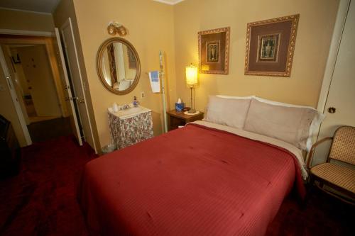 a bedroom with a red bed and a sink at The Courtland Hotel & Spa in Fort Scott