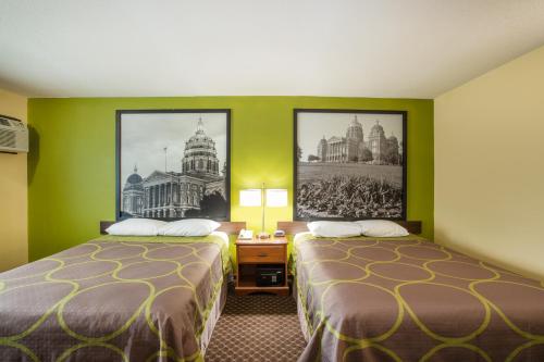 two beds in a hotel room with green walls at Super 8 by Wyndham Williams in Williams