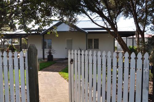 uma cerca branca em frente a uma casa em Girraween House em Coonawarra