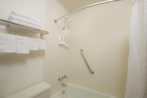 a white bathroom with a shower and a tub at Super 8 by Wyndham Williams in Williams