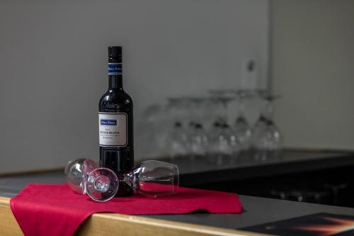 a bottle of wine and glasses on a red napkin at George Williams Hotel in Brisbane