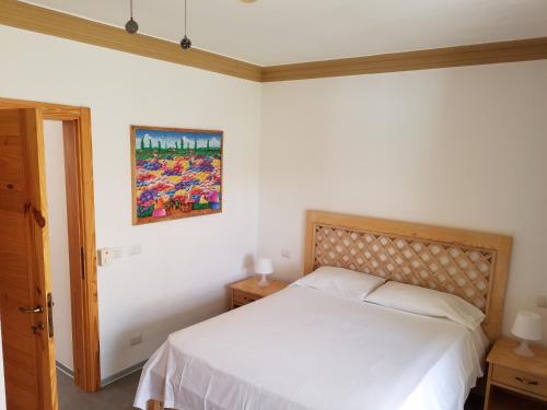 a bedroom with a bed and a painting on the wall at Las Palmeras RIKI R in Boca Chica