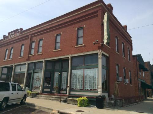 a red brick building with a white car parked in front at The Courtland Hotel & Spa in Fort Scott
