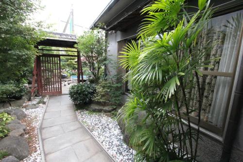 a garden with a gate and plants next to a building at I Osaka Traditional in Osaka