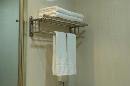 einen Handtuchhalter mit weißen Handtüchern im Bad in der Unterkunft Guangzhou Convention Center Apartment in Guangzhou